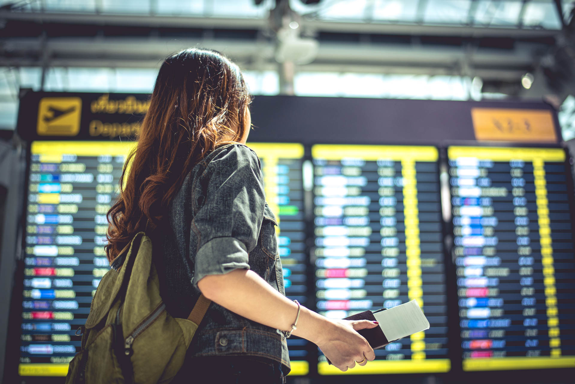 Beauty female tourist looking at flight schedules for checking t Mergers and Acquisitions